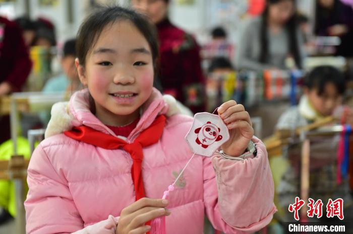 圖為一名小學(xué)生繡制的2022年北京冬奧會吉祥物“冰墩墩”形象?！∮髟屏?攝