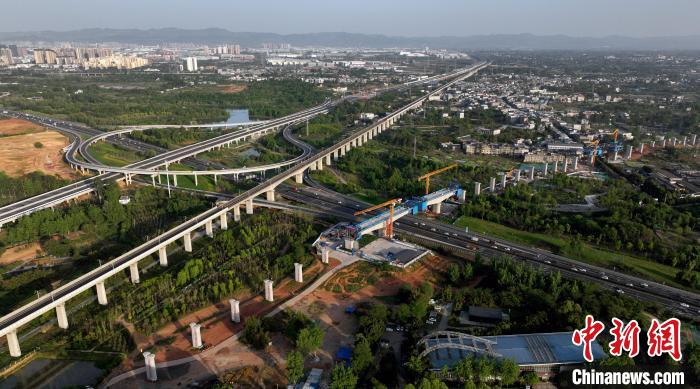 航拍正在建設(shè)的跨越成都繞城高速公路連續(xù)梁施工現(xiàn)場，旁邊依次為已運營的成渝高速鐵路和機場高速公路?！⒅铱?攝