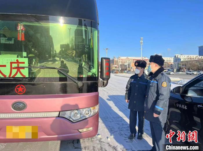交通執(zhí)法人員檢查客運車輛手續(xù)。　黑龍江省交通運輸廳供圖