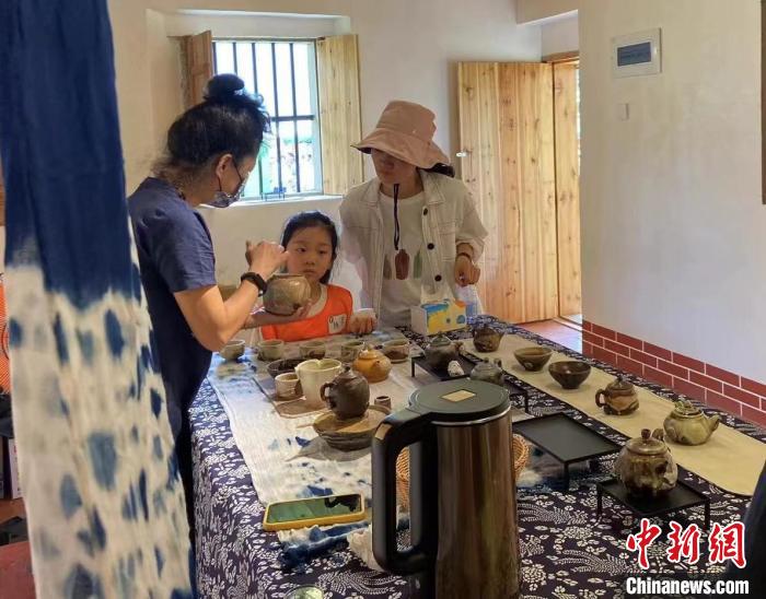 圖為：游客正在咨詢臺(tái)灣柴燒作品?！∪~秋云 攝