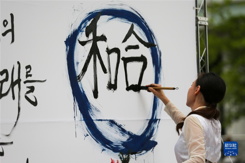 5月30日，在韓國首爾舉辦的“中日韓合作之日”慶?；顒又?，表演者進(jìn)行中日韓精神——2023年度漢字“和合”書法表演。新華社記者 王益亮 攝
