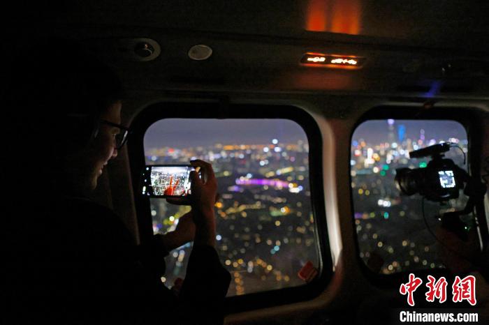 6月3日晚，游客乘坐上海新空直升機有限公司直升機開啟鳥瞰黃浦江空中圓夢之旅，并用手機拍攝城市夜景?！∫罅⑶?攝