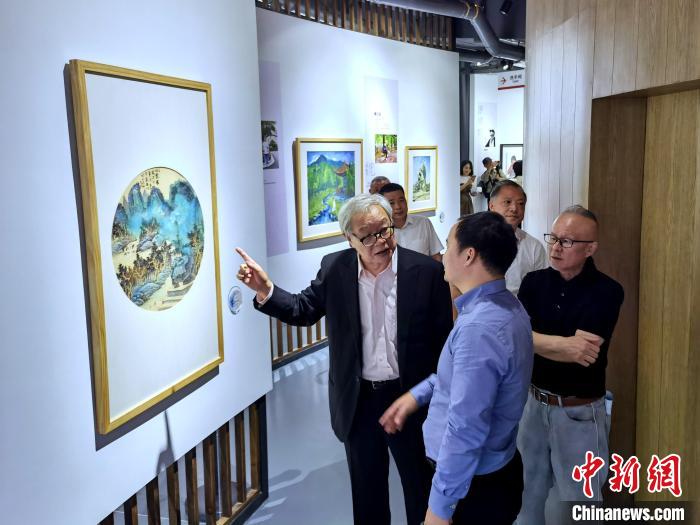 海峽兩岸藝術(shù)家畫展上，藝術(shù)家進(jìn)行藝術(shù)交流?！「毒窜?攝
