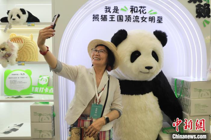 美國華視總裁楊蓮花與大熊貓文創(chuàng)產品合影?！⊥趵?攝