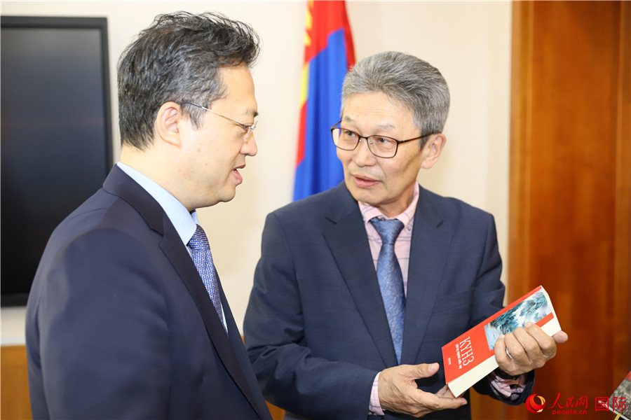 其米德策耶（右一）向李峙介紹翻譯成果。人民網(wǎng)記者 霍文攝
