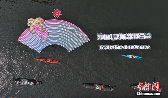資料圖為烏篷船和皮劃艇從杭州亞運(yùn)會標(biāo)識前劃過。王剛 攝