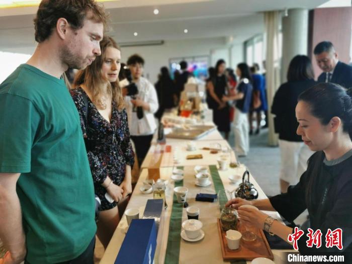 現(xiàn)場(chǎng)觀眾觀看中國(guó)展臺(tái)茶藝表演、了解茶文化。　靖樹(shù) 攝