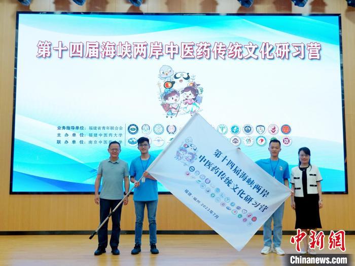 共青團福建省委副書記吳雪(右一)、福建中醫(yī)藥大學黨委副書記林羽(左一)為兩岸學生代表頒授營旗?！≡S燁婷 攝