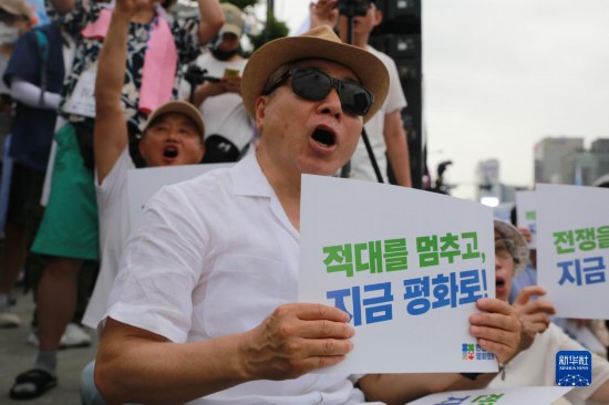 7月22日，在韓國首爾，人們手舉標語參與反戰(zhàn)游行。新華社發(fā)（楊暢 攝）