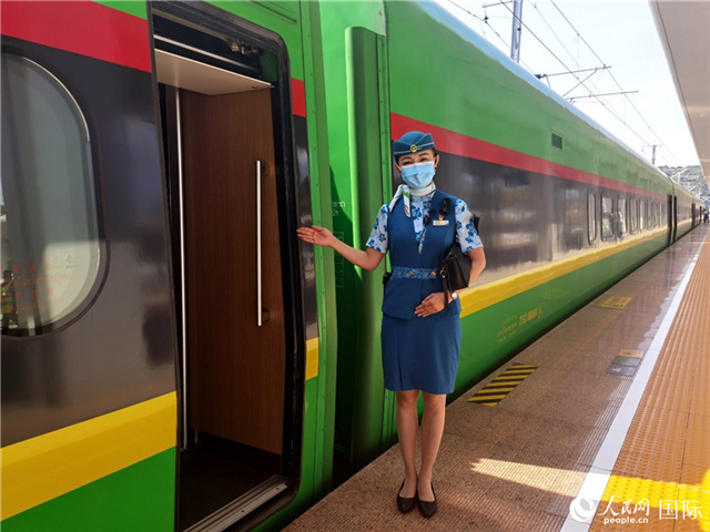 趙瑩靜站在“復(fù)興號”國際旅客列車車廂門口歡迎旅客上車。人民網(wǎng) 杜明明攝