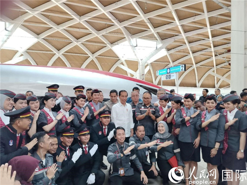印尼總統(tǒng)佐科與雅萬(wàn)高鐵乘務(wù)員及中印尼嘉賓合影。人民網(wǎng)記者 李培松攝