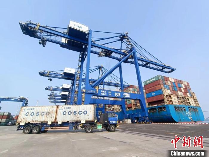 圖為海南洋浦國(guó)際集裝箱碼頭，卡車將集裝箱從后方堆場(chǎng)運(yùn)往碼頭裝卸區(qū)。　張?jiān)潞?攝