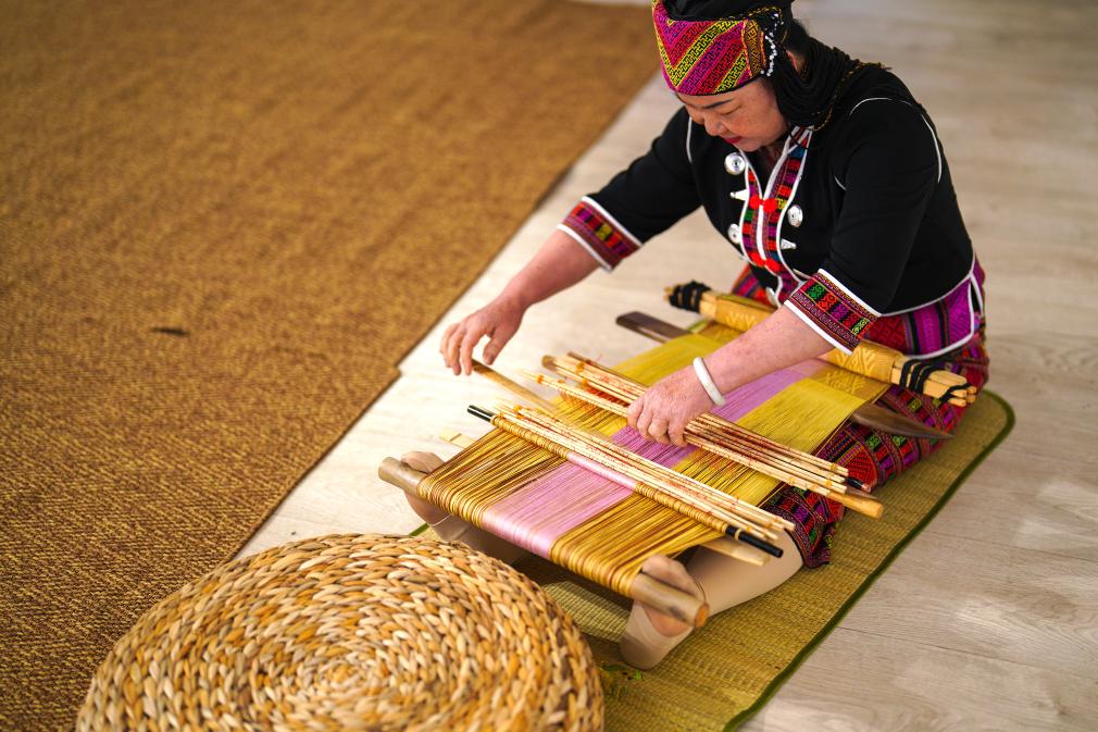 4月17日，黎族傳統(tǒng)紡染織繡技藝國家級代表性傳承人劉香蘭在2023年意大利米蘭設計周上展示黎錦織造技藝。新華社發(fā)