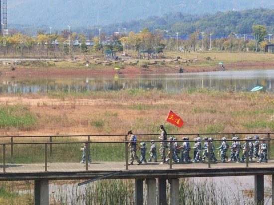 　　10月24日，秋游的幼兒園小朋友在老師帶領(lǐng)下走在清水塘公園里的木橋上。本報(bào)記者 常雯宜攝