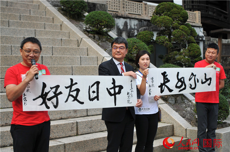 東京中國文化中心主任羅玉泉展示其為本次活動(dòng)書寫的題詞“中日友好，山高水長”。人民網(wǎng) 蔣曉辰攝