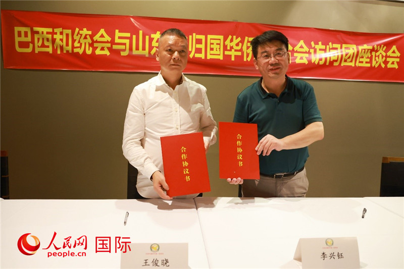 中國僑聯(lián)副主席、山東省僑聯(lián)主席李興鈺（右）與巴西和統(tǒng)會(huì)會(huì)長王俊曉簽署合作協(xié)議書。人民網(wǎng)記者 陳海琪攝