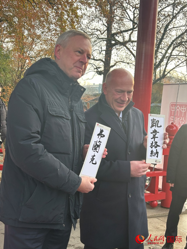 柏林市長(zhǎng)韋格納（右）、動(dòng)物園監(jiān)事會(huì)主席布魯克曼（左）手持中國(guó)文化中心工作人員現(xiàn)場(chǎng)手書(shū)的中文名字。人民網(wǎng)記者 徐馨攝