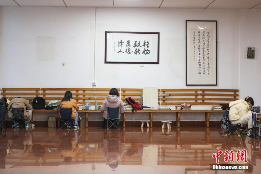 資料圖：幾位考研學(xué)生在南昌大學(xué)教學(xué)樓的公共空間復(fù)習(xí)備考。劉力鑫 攝