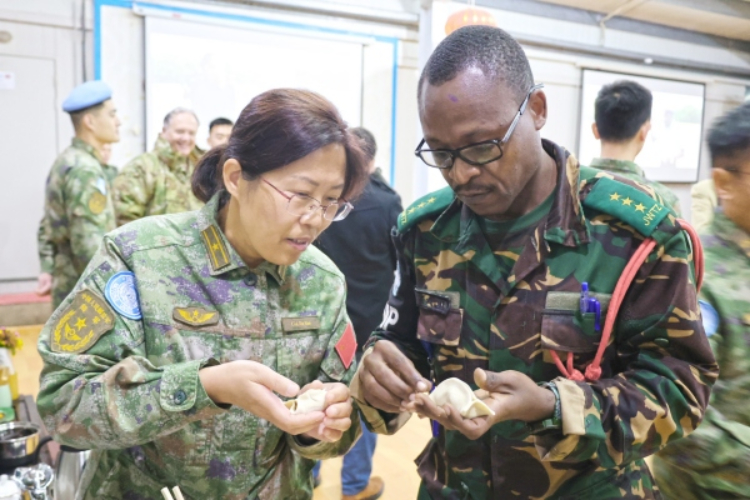 圖為維和官兵與外軍人員共同包餃子。胡光明攝