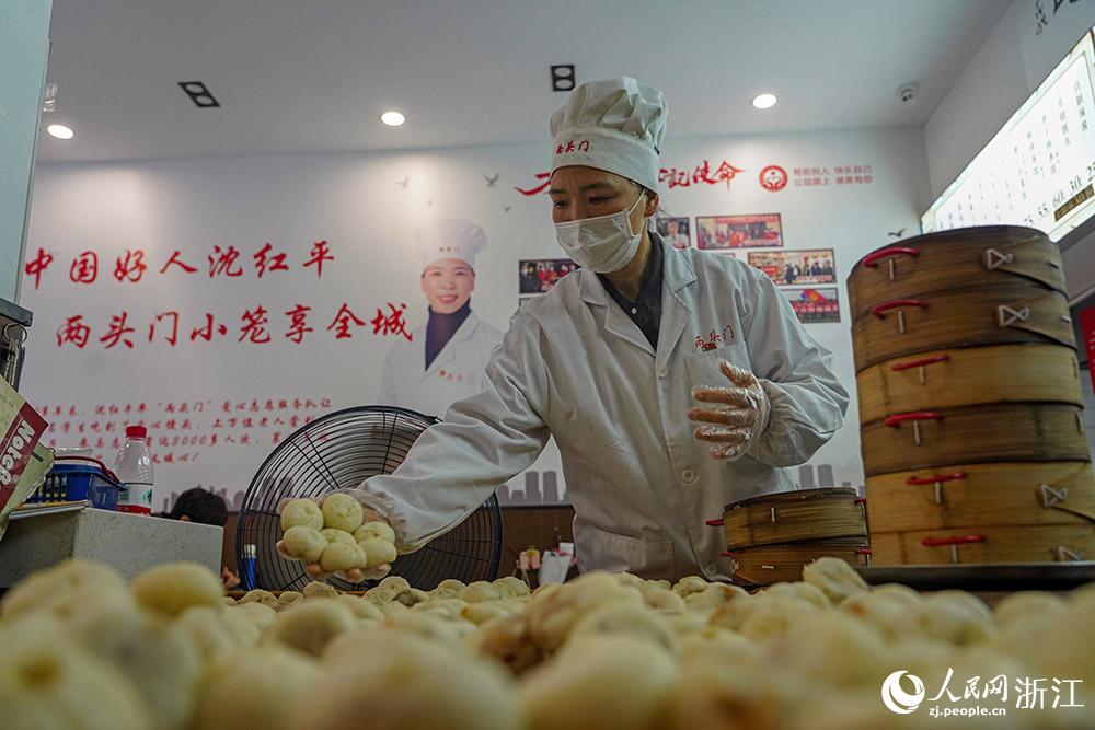 3月31日，在浙江省嵊州市甘霖鎮(zhèn)，嵊州小吃從業(yè)者沈紅平把蒸熟的小籠包晾涼，打包冷藏售賣。人民網(wǎng) 章勇濤攝