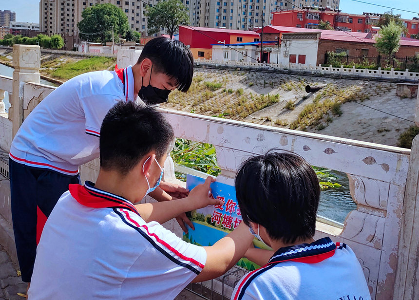 徐水小學(xué)學(xué)雷鋒志愿者在瀑河河邊張貼防溺水警示標(biāo)語。 徐水區(qū)委宣傳部供圖
