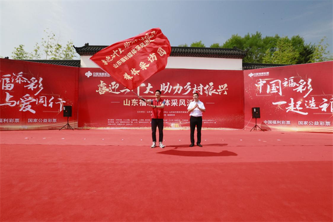 為媒體采風(fēng)團(tuán)授旗。 山東省福彩供圖