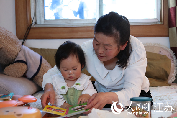 王繼蓮帶孫女看童書。人民網(wǎng) 冷金明攝