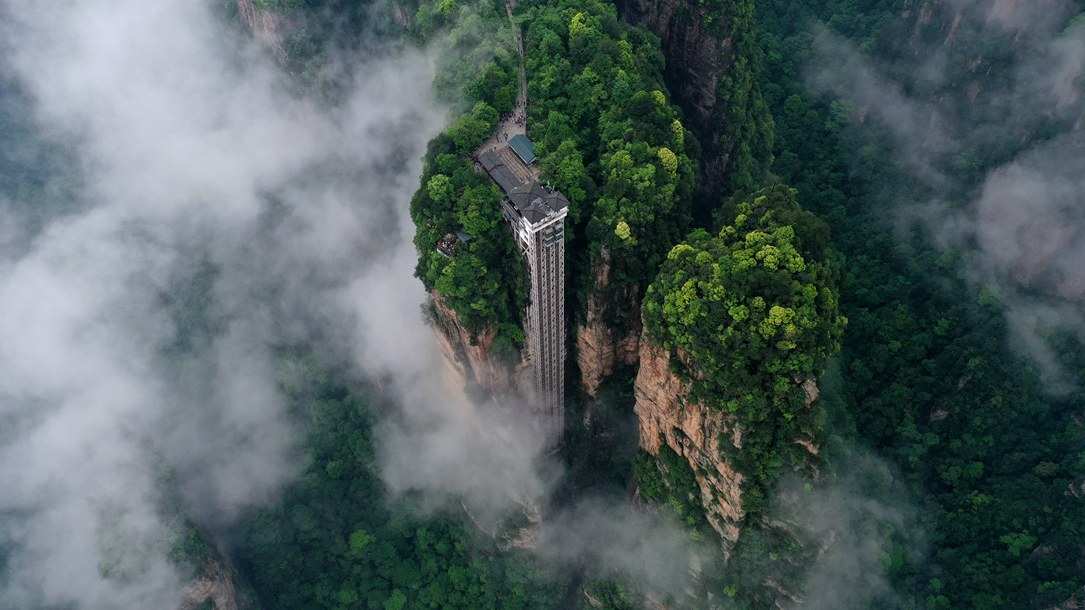 位于張家界武陵源景區(qū)的百龍?zhí)焯蓁偳对谠旗F繚繞的峰林間，雄偉壯觀。吳勇兵攝
