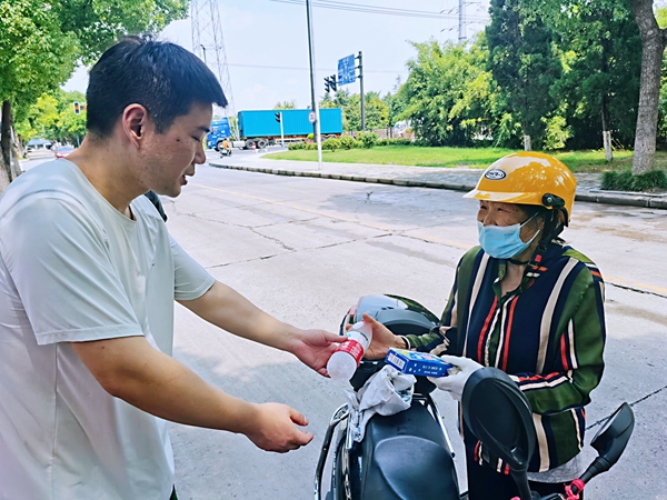 何超為過路的老人送上礦泉水和冷飲。人民網(wǎng)記者 王繼亮攝