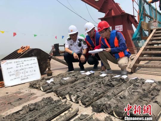 圖為勘察設計人員與海事局工作人員查看巖芯情況。　魏震 攝