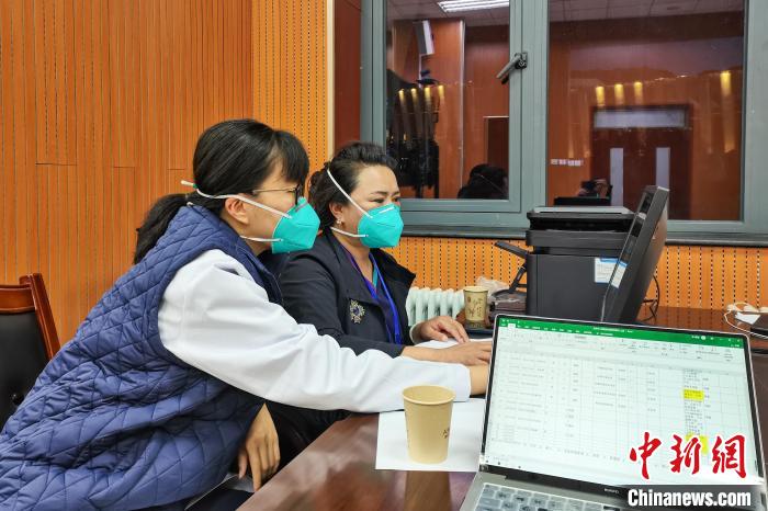 8月9日，楊蘇喬(左)在拉薩方艙醫(yī)院指揮部讀取艙內(nèi)患者胸部CT?！∈茉L者供圖