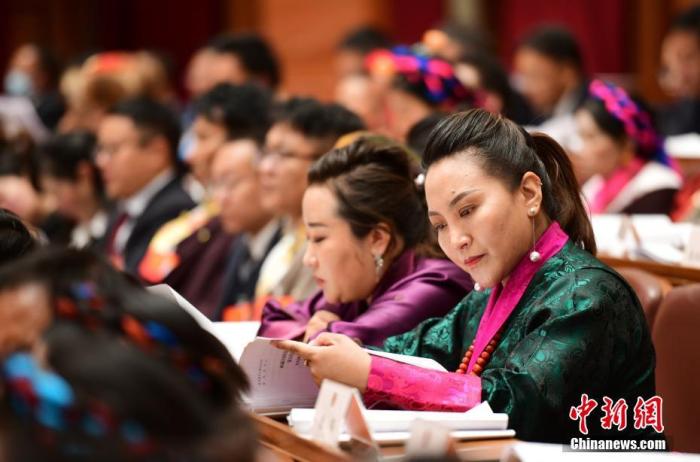 1月5日，次旦卓嘎(右一)在拉薩參加西藏自治區(qū)第十一屆人民代表大會第五次會議第二次全體會議。西藏自治區(qū)人大代表次旦卓嘎來自日喀則市定日縣，定日縣被稱為“洛諧故鄉(xiāng)”，作為西藏民間歌舞，洛諧已被列入中國國家非物質(zhì)文化遺產(chǎn)項(xiàng)目名錄，這是集歌、舞、樂、彈唱于一體的綜合藝術(shù)形式。參加完西藏2022年新年音樂會的次旦卓嘎告訴記者，每年參加的基層演出可達(dá)80場，“我希望用最純粹的方式，把最好的聲音帶到西藏乃至中國的各個(gè)角落?！?<a target='_blank' href='/'><p  align=