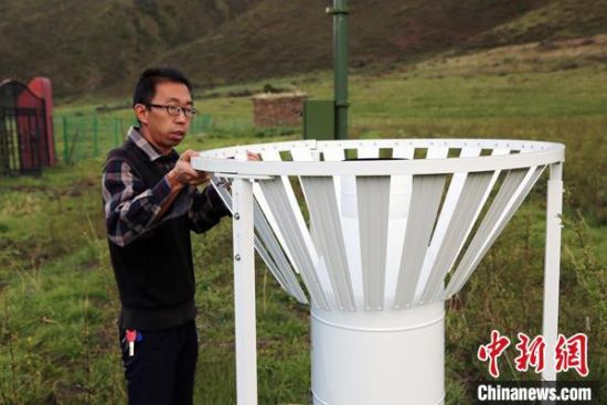 圖為班瑪縣氣象局工作人員在維護藏雪茶基地氣候站。青海省氣象局供圖