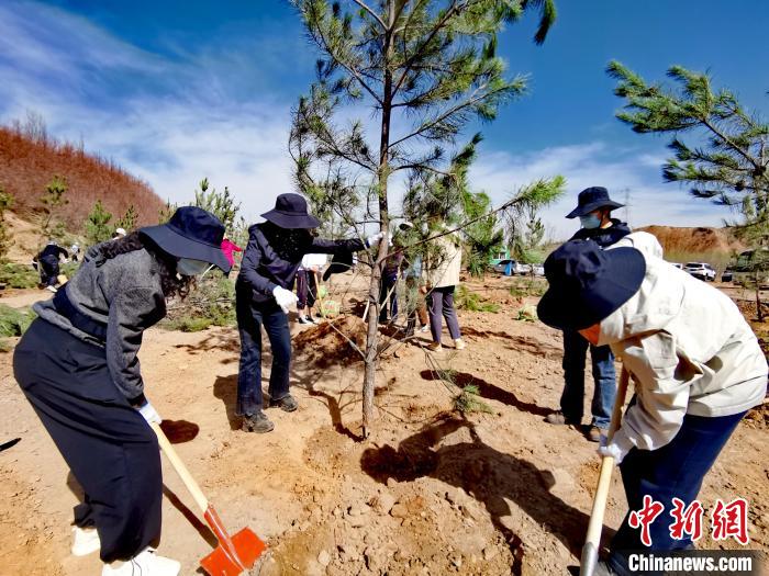 圖為西寧市城東區(qū)干部職工參加義務(wù)植樹?！?zhí)砀?攝