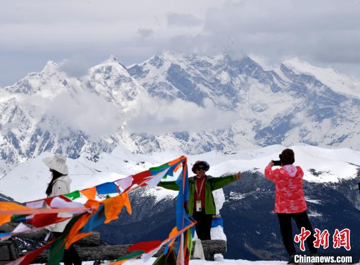 圖為5月14日，西藏林芝色季拉山觀景臺(tái)，游客與南迦巴瓦峰合影?！±盍?攝
