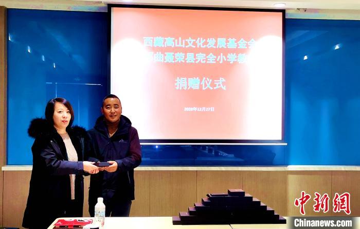 圖為西藏高山文化發(fā)展基金會理事長溫麗向聶榮縣完全小學負責人捐助儀器?！∮谫e 攝