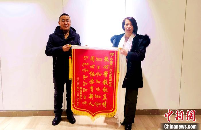 圖為聶榮縣完全小學向西藏高山文化發(fā)展基金會贈送錦旗。　于賓 攝