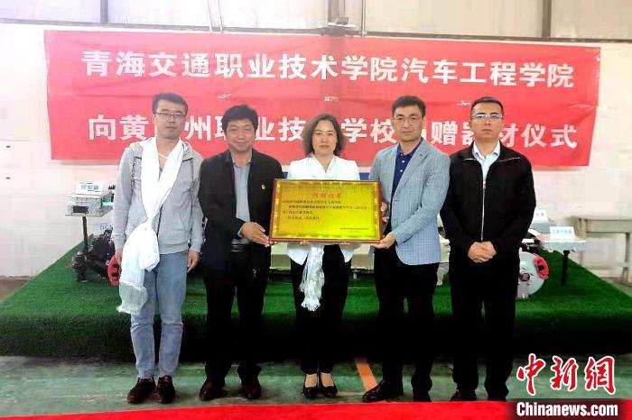 圖為李富香(中)代表學(xué)校為州縣技校捐贈(zèng)器材。(資料圖) 青海省教育廳供圖