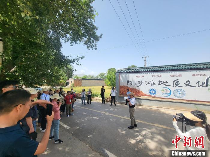 圖為中國(guó)地質(zhì)大學(xué)(北京)教授張緒教介紹村落情況。　胡友軍 攝
