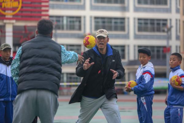 在高原上教孩子們打手球，“慢慢兒來，甭著急！”