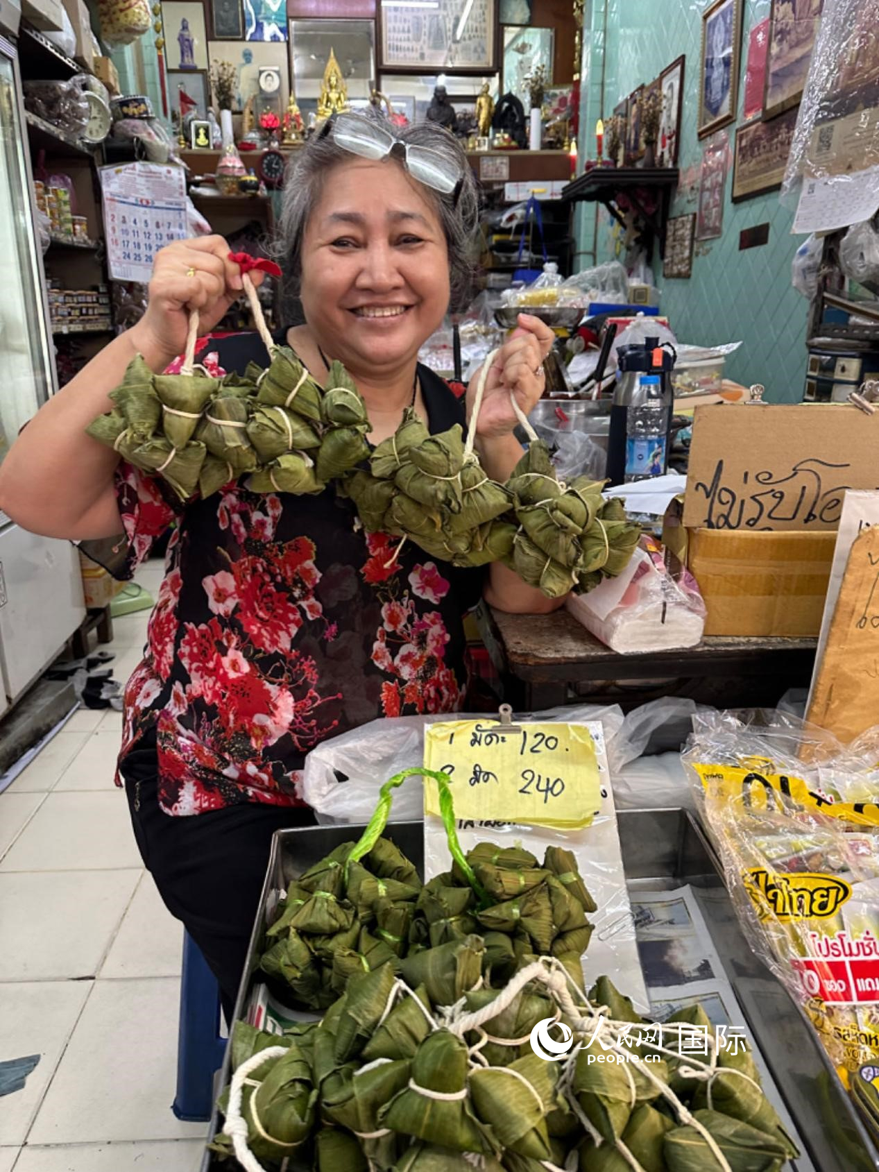 商家向顧客介紹“吉掌”（粽子的一種，一串一串，個頭較小）。人民網(wǎng)記者 簡承淵攝