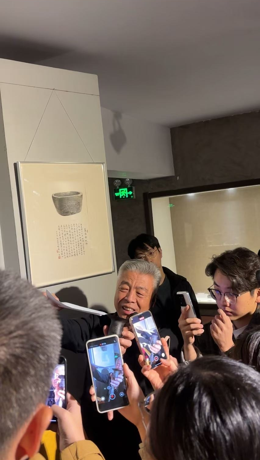 黑陶邢文化博物館館長邢葆東展示兩張相疊的A4紙，向記者解釋此為杯口的厚度。