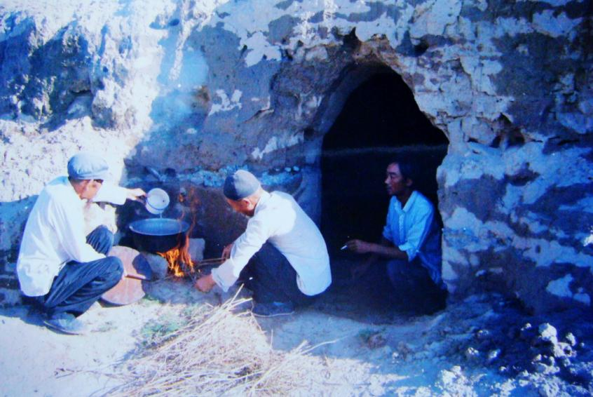 1983年，“六老漢”一代治沙人在“地窩子”生活做飯。新華社發(fā)（八步沙林場供圖）
