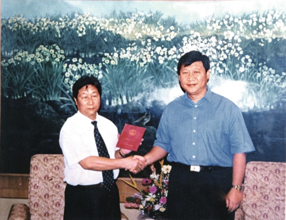 2000年7月，習近平為福建農(nóng)林大學教授林占熺頒發(fā)福建省政府“一等功”榮譽證書。圖源：《習近平在福建》（下）