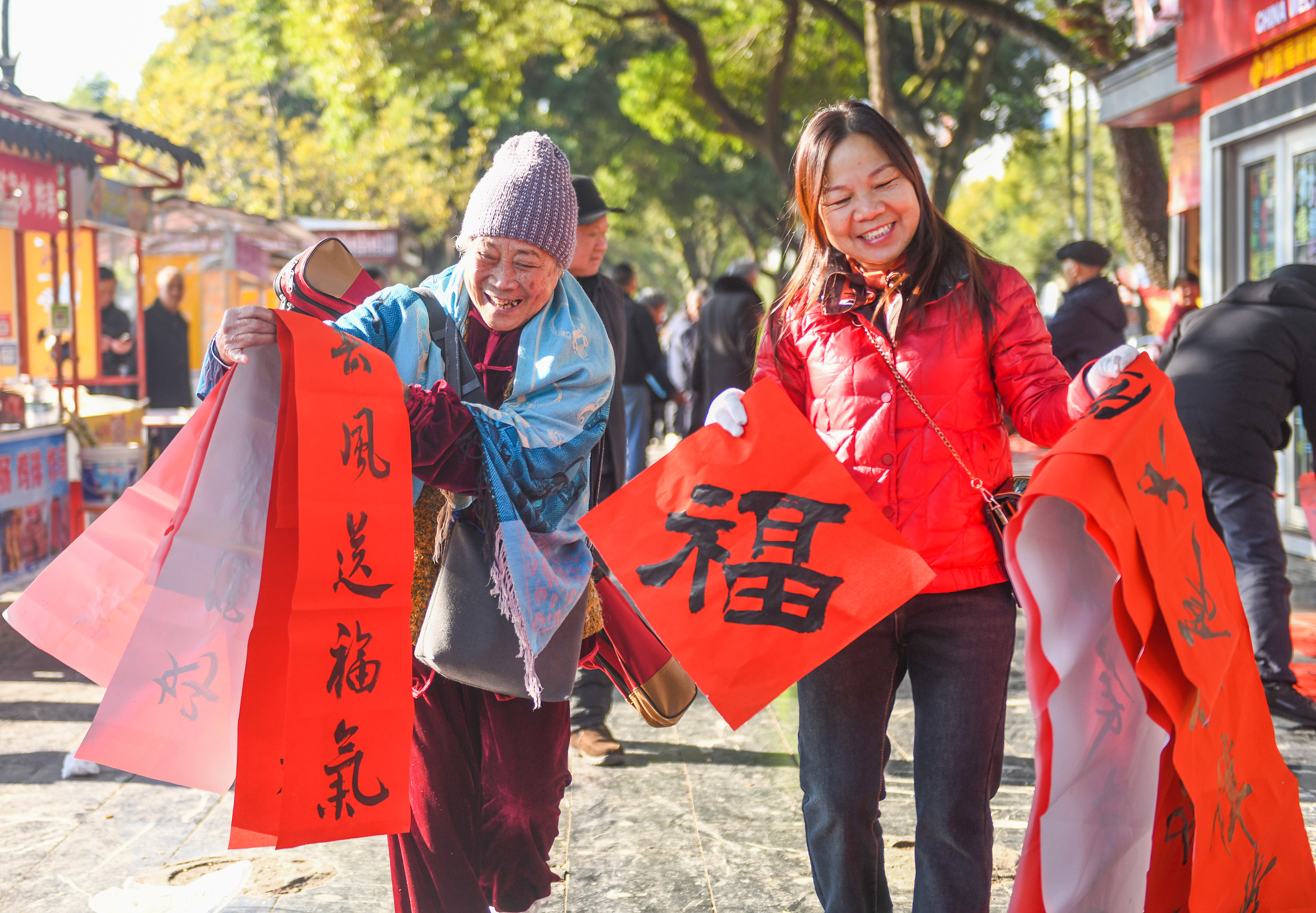 2025年1月13日，在湖南省永州市道縣西洲公園義工崗亭，市民們領到了書法志愿者為大家書寫的春聯(lián)。