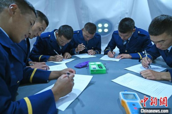 圖為消防員在高壓氧艙內(nèi)填寫問卷。　趙朗 攝