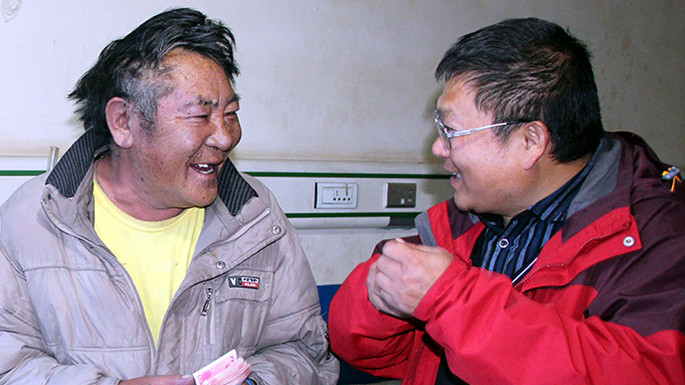 6、這是中國石化援藏干部王鵬雁（右）來到???結對子”幫扶對象的扎扎（左）家中，為他妻子英秋治病送去自掏腰包的??????需的治療費（扎??2014??7??9日攝）_副本.jpg
