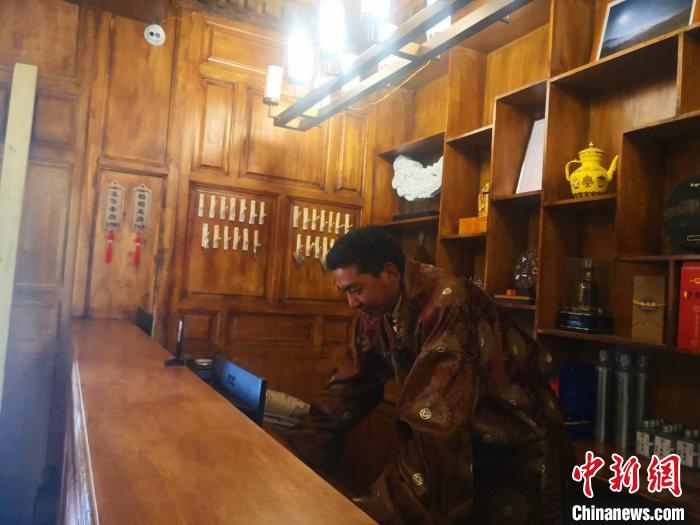 圖為桑杰才讓用電腦處理財務?！∈缝o靜 攝