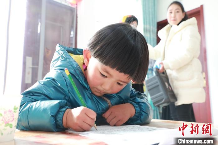孩子們?cè)诩议T口上學(xué)，是楊周馬草搬入蘭州新家最為開心的事情。小女兒楊洋正在學(xué)習(xí)寫數(shù)字?！∥航ㄜ?攝