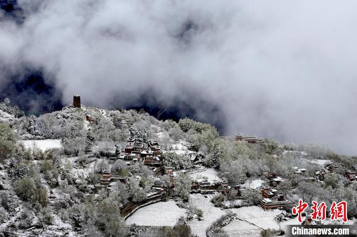 雪后的藏寨和碉樓構(gòu)成美麗的雪景?！〗党鯘衫?攝